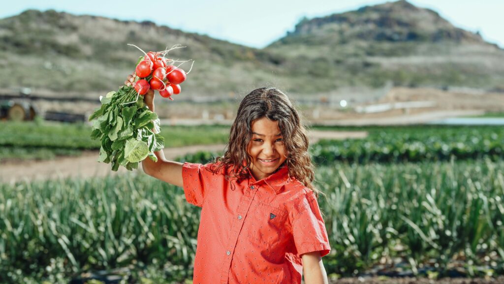 Photo of a Child Holding Radishes